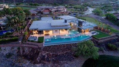 Overhead view of house with backyard pool illuminated at night Photo