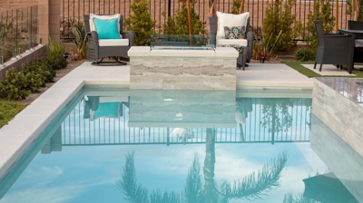 Custom backyard pool design with fire feature and seating Photo