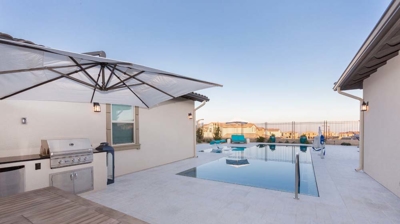 Outdoor kitchen and view of pool Photo