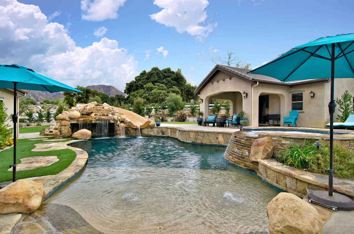 large backyard with custom pool with waterfall and spa
